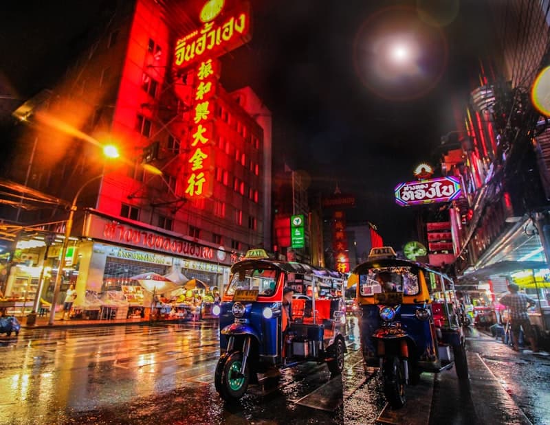 Neon signage above a busy Bangkok street at night